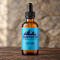 Fjord Beard Oil in its cyan-labeled amber dropper bottle on rustic wood against a stone backdrop