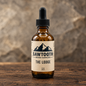 Lodge Beard Oil in its cream-labeled amber dropper bottle on rustic wood against a stone backdrop