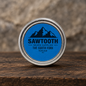 South Fork Beard Balm in its blue-labeled silver tin on rustic wood against a stone backdrop